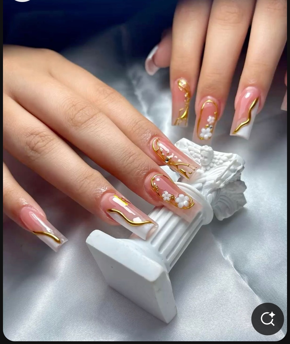 Pink and white nails with flowing gold line work and daisy accents